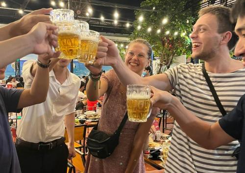 een groep mensen die een glas bier omhoog houden bij Gikgo Can Tho in Can Tho