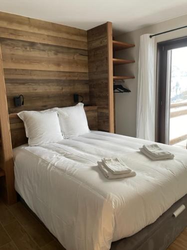 a bedroom with a large bed with two towels on it at Magnifique chalet sur les pistes, le Paradis c'est là! in La Toussuire