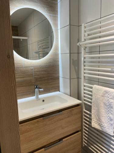 une salle de bain avec un lavabo et un miroir dans l'établissement Magnifique chalet sur les pistes, le Paradis c'est là!, à La Toussuire