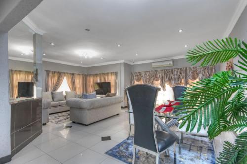 sala de estar con sofá y mesa en The Royal Residence, en Johannesburgo