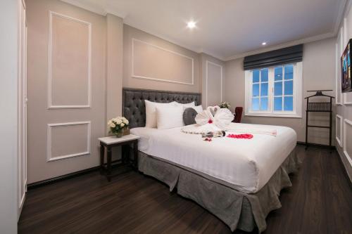Un dormitorio con una gran cama blanca con flores. en Flora Centre Hotel & Spa en Hanói