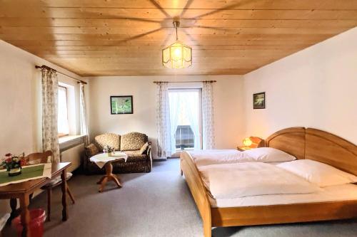 a bedroom with two beds and a wooden ceiling at Pension Luger in Aschau im Chiemgau