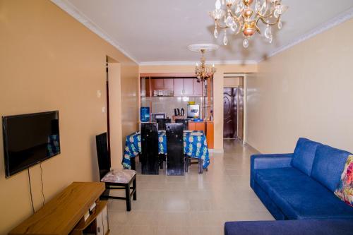 a living room with a blue couch and a table at Nairobi Airport Apartments in Syokimau