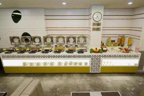 a counter with plates and a clock on the wall at Hotel Sifat International in Surat