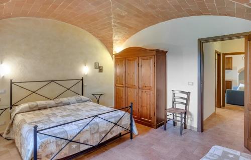 a bedroom with a bed and a chair in a room at Agriturismo Casale Giulia in Volterra