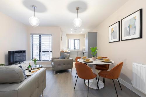 ein Wohnzimmer mit einer Couch und einem Tisch und Stühlen in der Unterkunft Elliot Oliver - Chic 2 Bedroom Town Centre Apartment in Cheltenham