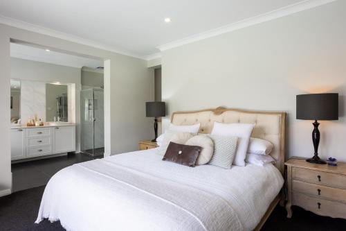 a bedroom with a white bed and a bathroom at Soulful Grande Manor with Mineral Pool in Millfield