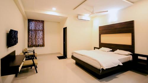 a bedroom with a large bed and a desk and a desk at Namastay welcome home - Abu Road in Ābu Road