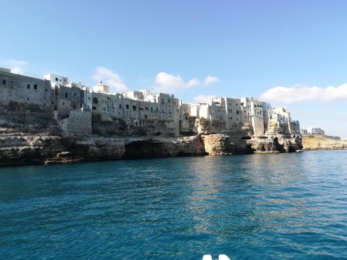 een uitzicht op de stad vanaf een boot in het water bij MandorleOlio in Polignano a Mare