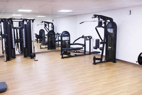 a gym with a bunch of tread machines in a room at Spacious modern 2 bedroom apartment in Dubai