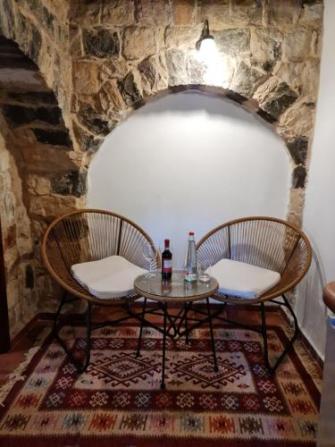 two chairs and a table with a bottle of wine at וילה תהילה המחודש - The new Villa Tehila in Rosh Pinna