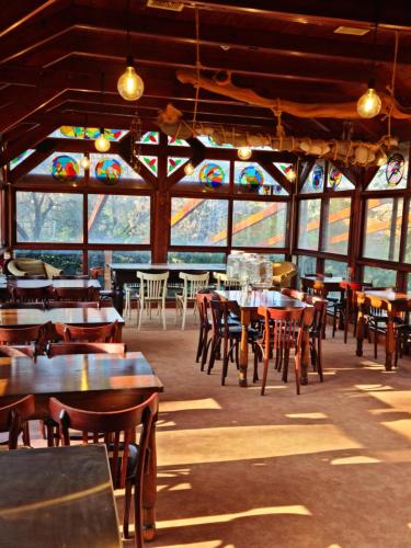 un ristorante con tavoli, sedie e vetrate istoriate di וילה תהילה המחודש - The new Villa Tehila a Rosh Pinna