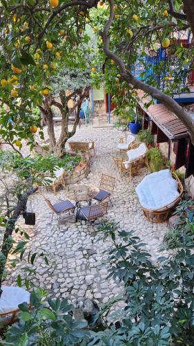 an outdoor patio with chairs and tables and orange trees at וילה תהילה המחודש - The new Villa Tehila in Rosh Pinna