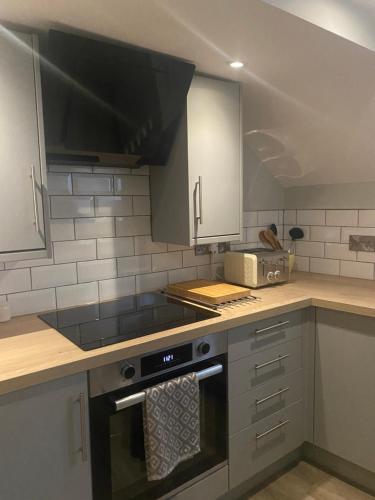 a kitchen with a stove and a microwave at The White Hart Apartment Church View in Alton