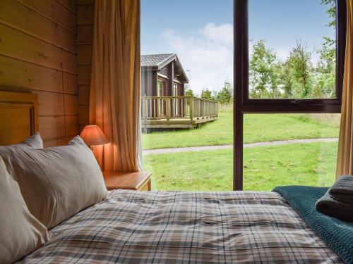 a bedroom with a bed and a large window at The Shed in Woolfardisworthy