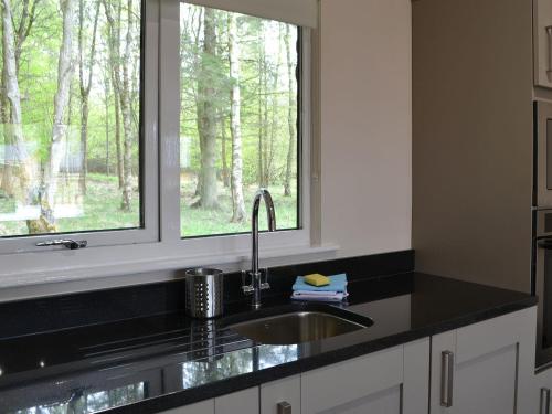 cocina con fregadero y ventana en Reivers Rest, en Otterburn