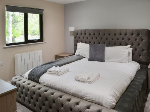 1 dormitorio con 1 cama grande y cabecero de cuero en Reivers Rest en Otterburn