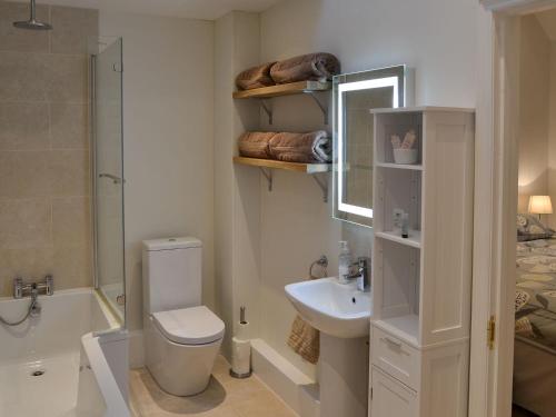 uma casa de banho com um WC, um lavatório e uma banheira em Blyth Green Stable em Long Stratton