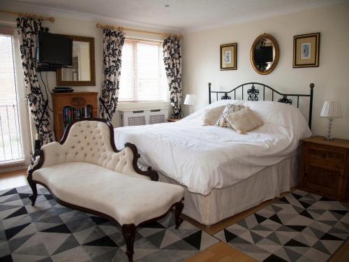 a bedroom with a large bed and a chair at Harbour View in Pevensey