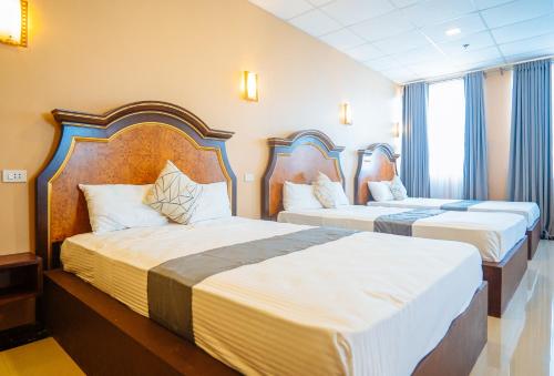 Cette chambre d'hôtel comprend 2 lits avec des draps blancs. dans l'établissement RedDoorz Plus @ Hotel Platinum Occidental Mindoro, à San Jose