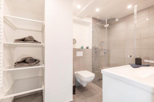 ein weißes Bad mit einem WC und einer Dusche in der Unterkunft Ferienwohnung Sonnenschein Haus Hiddensee Prora in Binz
