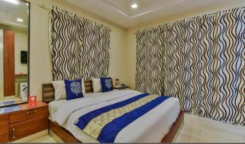 a bedroom with a large bed and a mirror at Sea Breeze Beach Resort Murud in Murud