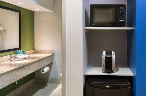 a bathroom with a sink and a microwave at Holiday Inn Express Cedar Rapids - Collins Road, an IHG Hotel in Cedar Rapids