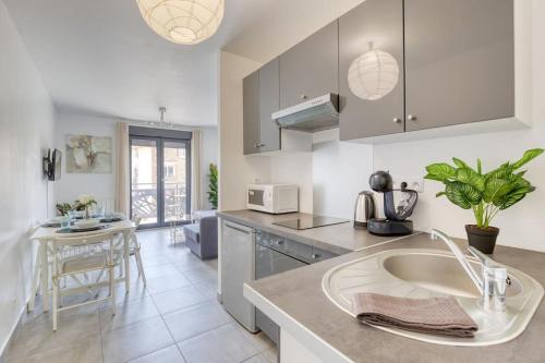 une cuisine avec un évier et un plan de travail dans l'établissement Le Central - Parking - 10' Paris - 30' Disneyland, à Fontenay-sous-Bois