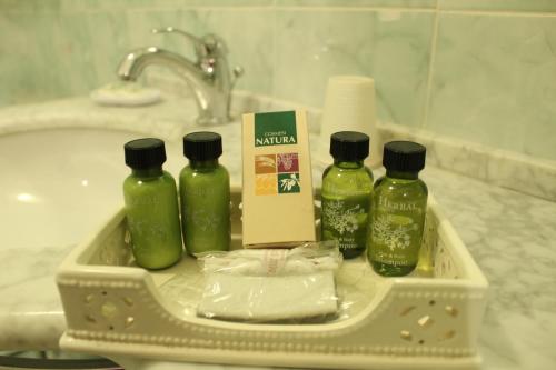 a tray with four bottles of soap and a sink at Hotel Belle Epoque in Sanremo