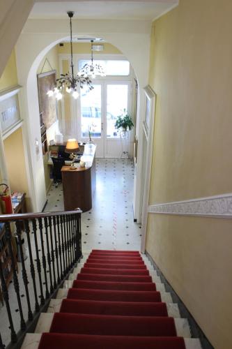 a staircase with a red carpet in a hallway at Hotel Belle Epoque in Sanremo