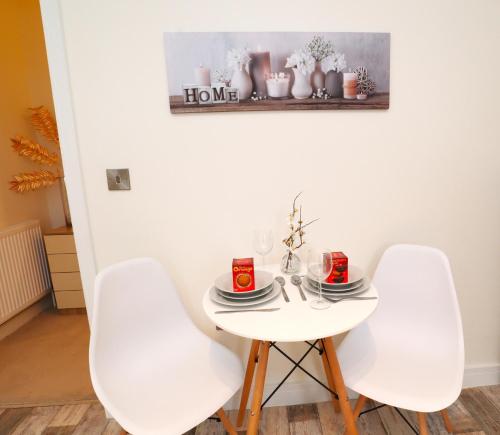 einem weißen Tisch mit zwei weißen Stühlen und einem Teller mit Essen in der Unterkunft The Lottbridge in Eastbourne
