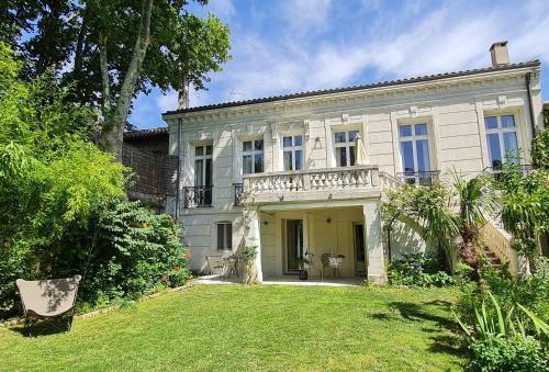 Cette grande maison blanche dispose d'un balcon sur la cour. dans l'établissement Villa Aigarden maison d'hôtes, à Avignon