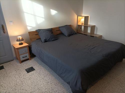 een slaapkamer met een groot bed met blauwe kussens bij Gite de la Croix de la Passion in Vailly-sur-Sauldre