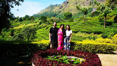 a group of three people standing in a garden at Blackcherry Munnar in Munnar