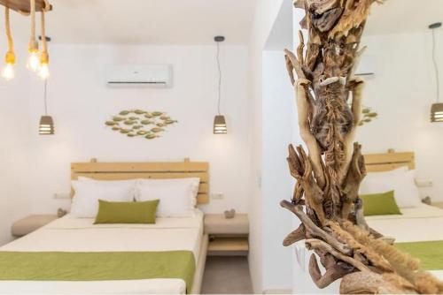 two beds in a room with a tree trunk between them at Blue Heart Luxury Suites in Naxos Chora