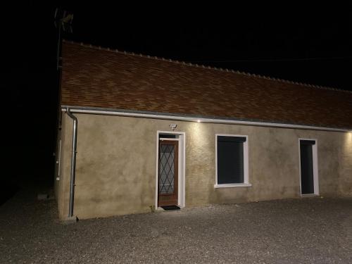 un petit bâtiment avec une porte dans l'obscurité dans l'établissement Logement individuel circuit 24h du Mans ou autre, à Parigné-le-Pôlin