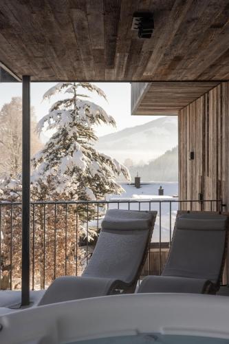a room with chairs and a view of the water at GOING TRIPLE A apartments WEST in Going