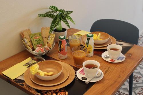 une table en bois avec des assiettes de nourriture et des tasses de café dans l'établissement Agriturismo Ortaglia Bardolino, à Bardolino