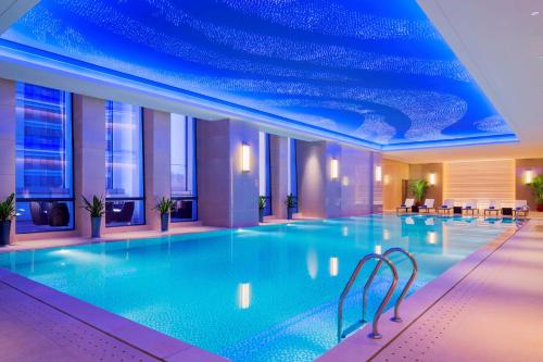 a swimming pool in a hotel with a blue ceiling at Wanda Realm Guangzhou Zengcheng in Zengcheng