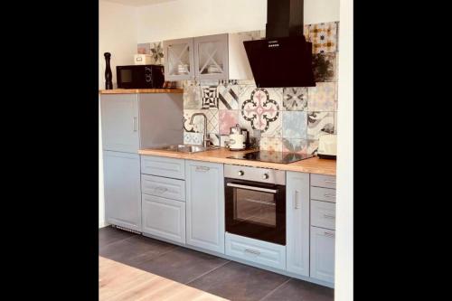 a kitchen with white cabinets and a stove top oven at Pension Eichel in Rust