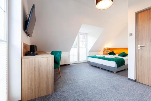 a bedroom with a bed and a tv in a room at Willa Pod Janowcem SPORT - REST & SPA in Stronie Śląskie