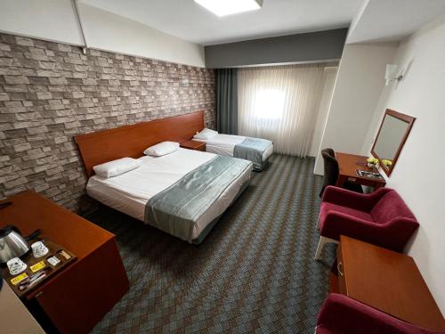 a hotel room with two beds and a chair at ERCİYES HİLL in Erciyes
