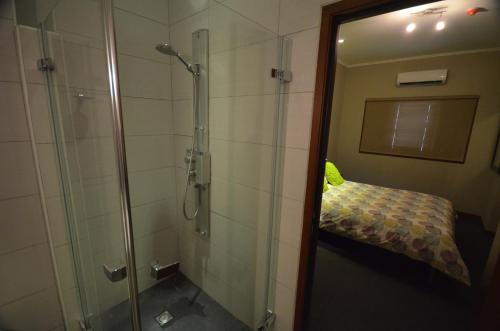 baño con ducha y cama. en Spanish Water Beach Resort, en Willemstad