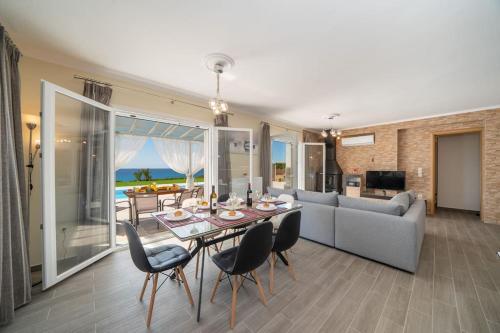 a living room with a table and chairs and a couch at Villa Kassiani in Svoronata