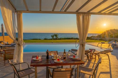 a table on a patio with a view of the ocean at Villa Kassiani in Svoronata