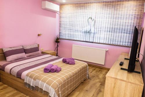 Un dormitorio con una cama con almohadas moradas. en KRISSTY Apartment en Veliko Tŭrnovo