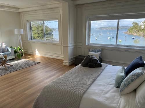 a bedroom with a large window with boats in the water at Tusan Villa Little Manly in Sydney