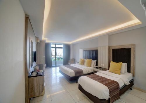 a hotel room with two beds and a television at Shweiki International Hotel in Aqaba