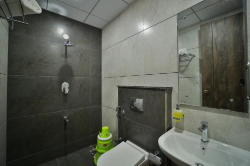 a bathroom with a sink and a toilet and a mirror at The Mysore Grand in Mysore