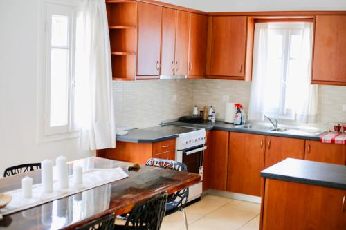 a kitchen with wooden cabinets and a counter top at Villa Giulia, seaview villa in Ios Chora